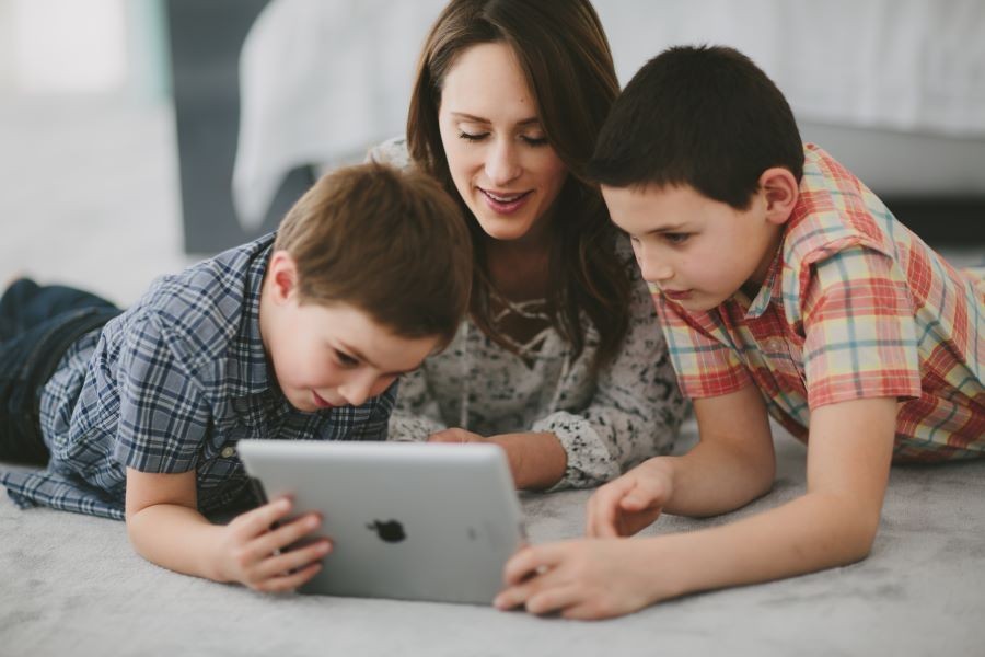 A woman and two children using an iPad.