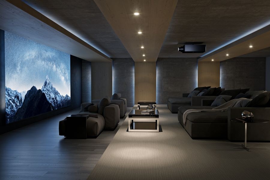 A large home theater with a Sony projector, large movie screen, and chaise lounges.