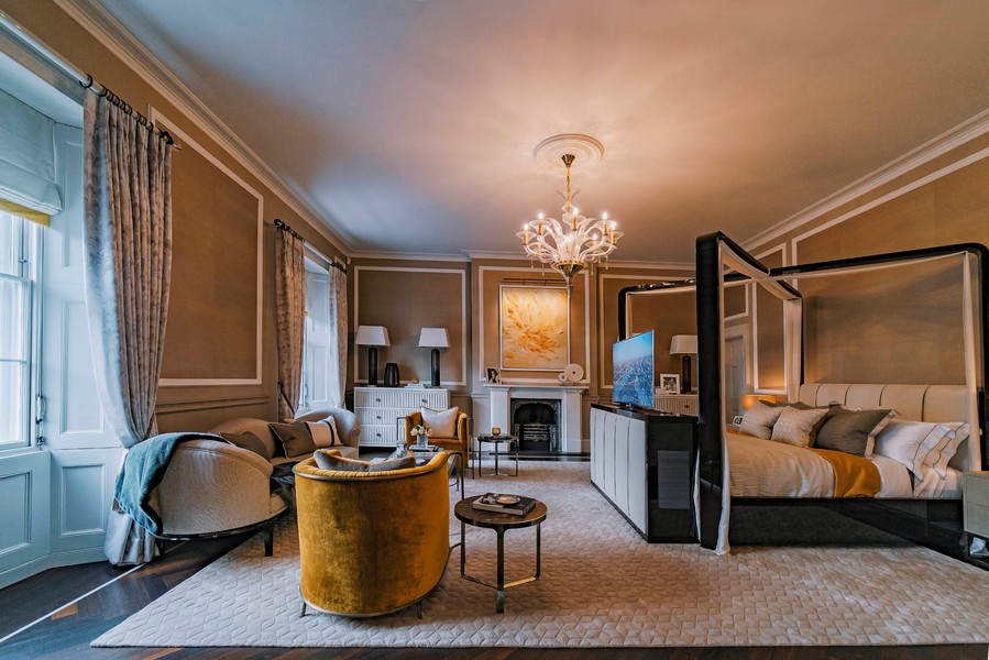 A luxurious Chicago master bedroom featuring a TV rising from a niche at the foot of the bed. 