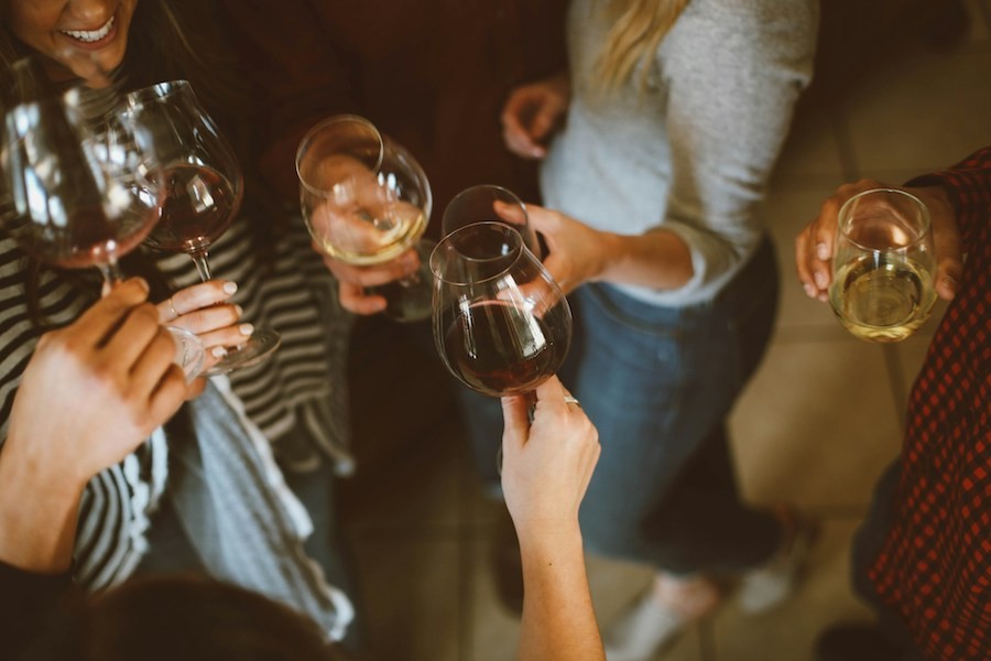 Several women enjoy drinks outdoors at an evening outdoor party. 