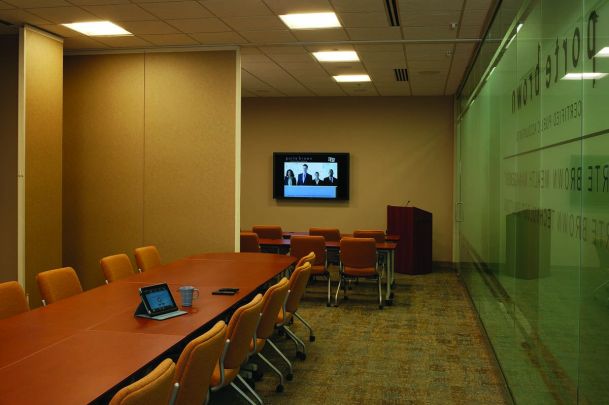 Commercial board room with multiple tiles on the TV and smart room control